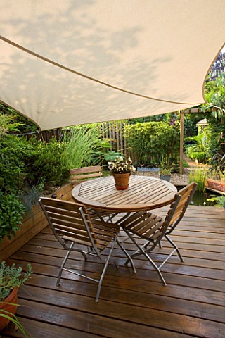 WOODEN_DECKING_WITH_WOODEN_TABLE_AND_CHAIRS__SHADE_CANOPY__CANVAS_KATHY_TAYLORS_SMALL_TOWN_GARDEN__L