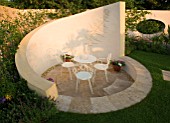 HAMPTON COURT FLOWER SHOW 2006: DESIGNER - PHILIP OSMAN - CREAM COLOURED WALL AND SUNKEN SEATING AREA WITH CHAIRS AND TABLE