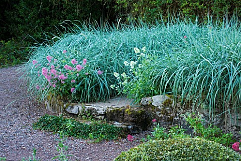 VEDDW_HOUSE_GARDEN__GWENT__WALES_DESIGNERS_ANNE_WAREHAM_AND_CHARLES_HAWES__STONE_WALL_PLANTED_WITH_L