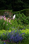 VEDDW HOUSE GARDEN  GWENT  WALES: DESIGNERS ANNE WAREHAM AND CHARLES HAWES - THE CRESCENT BORDER WITH BUZZARD CUT OUT SCULPTURE  EPILOBIUM ANGUSTIFOLIUM  ALCHEMILLA AND NEPETA