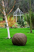 WOODPECKERS  WARWICKSHIRE  WINTER: WOVEN WILLOW BALL SCULPTURE WITH BETULA HERGEST AND A WOODEN PERGOLA
