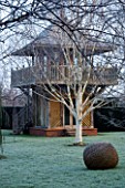 WOODPECKERS  WARWICKSHIRE  WINTER: FORMAL GARDEN IN FROST WITH LAWN  WOVEN WILLOW SCULPTURE  BETULA UTILIS VAR JACQUEMONTII AND WOODEN SUMMERHOUSE