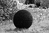 DESIGNER: DAVID HARBER. GARDEN DESIGNED BY ANGEL COLLINS - PEBBLE SPHERE IN WILDFLOWER MEADOW. BLACK AND WHITE IMAGE
