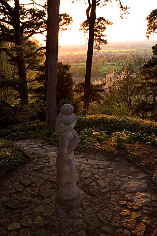 KIFTSGATE_COURT__GLOUCESTERSHIRE_MOTHER_AND_CHILD_STATUE_BY_SIMON_VERITY_BESIDE_SCOTCH_FIRS_EVENING_