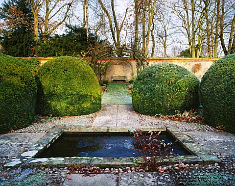 A_POOL_SURROUNDED_BY_BOX_BALLS_AT_THE_CENTRE_OF_THE_OLD_COB_WALLED_VEGETABLE_GARDEN_AT_HEALE_HOUSE__