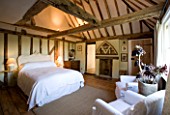 BOONSHILL FARM  EAST SUSSEX. INTERIOR OF BEDROOM WITH WOODEN FLOORBOARDS AND EXPOSED BEAMS. DESIGNER: LISETTE PLEASANCE