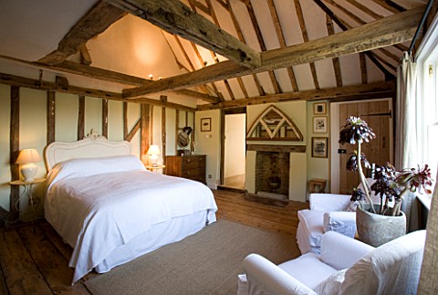 BOONSHILL_FARM__EAST_SUSSEX_INTERIOR_OF_BEDROOM_WITH_WOODEN_FLOORBOARDS_AND_EXPOSED_BEAMS_DESIGNER_L