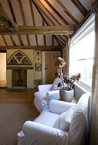 BOONSHILL_FARM__EAST_SUSSEX_INTERIOR_OF_BEDROOM_WITH_WOODEN_FLOORBOARDS__EXPOSED_BEAMS_AND_LINEN_COV