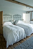 BOONSHILL FARM  EAST SUSSEX. INTERIOR OF GUEST BEDROOM WITH ANTIQUE LACE BEDSPREADS AND METAL GATES AS BEDHEADS. DESIGNER: LISETTE PLEASANCE