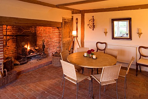 BOONSHILL_FARM__E_SUSSEX_INTERIOR_OF_KITCHEN_WITH_INGLENOOK_FIREPLACE__TABLE_AND_CHAIRS__TRIPOD_LAMP