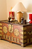 BOONSHILL FARM  EAST SUSSEX. ANTIQUE INDIAN WOOD AND BRASS DOWRY CHEST WITH LAMP AND ORNAMENTALS.  DESIGNER: LISETTE PLEASANCE