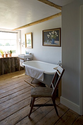 BOONSHILL_FARM__EAST_SUSSEX_INTERIOR_OF_BATHROOM_WITH_OLD_ROLLTOP_CLAWFOOT_BATH__ANTIQUE_CHAIR_FROM_