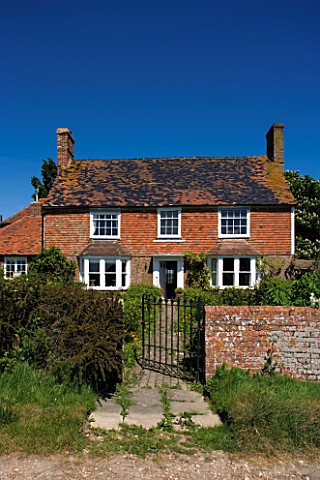 BOONSHILL_FARM__EAST_SUSSEX_OWNER_LISETTE_PLEASANCE_EXTERIOR_OF_HOUSE_WITH_METAL_GATE