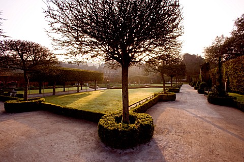 HOLKER_HALL__CUMBRIA__THE_SUNKEN_GARDEN_AT_DUSK_WITH_BOX_HEDGING__LAWN_AND_STATUARY_FORMAL_GARDEN