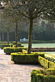 HOLKER HALL  CUMBRIA - DAWN LIGHT ON BOX HEDGING AND LAWN IN THE FORMAL GARDEN IN SPRING WITH BENCH BEYOND