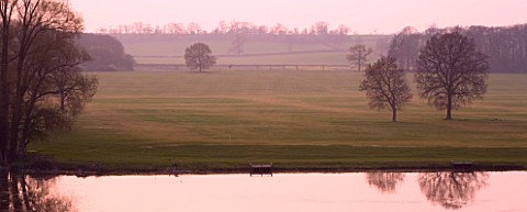 KELMARSH_HALL__NORTHAMPTONSHIRE_VIEW_OF_THE_LAKE_AND_COUNTRYSIDE_BEYOND_AT_DUSK_SUNSET_LANDSCAPE__PE