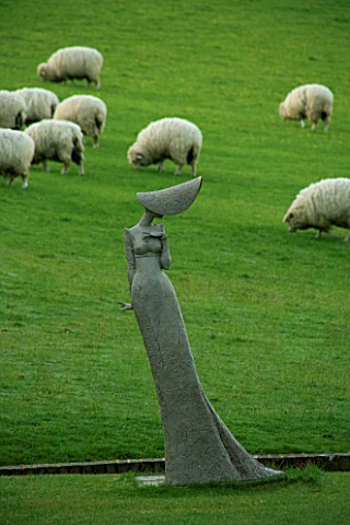 PASHLEY_MANOR__EAST_SUSSEX_MR_BENNETS_DAUGHTER_SCULPTURE_BY_PHILIP_JACKSON_BESIDE_A_HA_HA_WITH_SHEEP