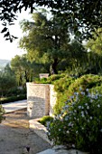 CORFU  GREECE: VILLA ZOGRAFIA  NORTH EAST CORFU. DESIGN BY ALITHEA JOHNS OF SKOPOS DESIGN AND RAHDY ELWAN. COURTYARD WITH WALL AND OLIVE TREES