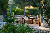 CORFU  GREECE. MALAMA HOUSE NEAR BARBATI. PATIO DINING AREA WITH PERGOLA  TABLE AND CHAIRS SET FOR ALFRESCO DINING. EVENING LIGHT  ROMANTIC  AMBIENCE  RELAXING  RELAXED