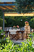 CORFU  GREECE. MALAMA HOUSE NEAR BARBATI. PATIO DINING AREA WITH TABLE AND CHAIRS SET FOR ALFRESCO DINING. EVENING LIGHT  ROMANTIC  AMBIENCE  RELAXING  RELAXED