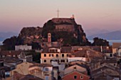 CORFU  GREECE: VIEW OF CORFU TOWN ROOFTOPS AND THE OLD FORTRESS AT SUNSET