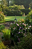MARINERS GARDEN  BERKSHIRE. DESIGNER FENJA ANDERSON - VIEW INTO THE ROSE GARDEN TO THE WATER LILY POOL WITH HERON SCULPTURE. ROSES FANTIN LATOUR AND PROSPERITY