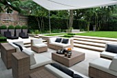 CONTEMPORARY TOWN/URBAN/CITY GARDEN DESIGNED BY CHARLOTTE SANDERSON: ENTERTAINING/RELAXING AREA WITH AWNING  TABLE  CHAIRS  SOFAS AND STEPS LEADING TO LAWN