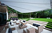 CONTEMPORARY TOWN/CITY/URBAN GARDEN DESIGNED BY CHARLOTTE SANDERSON: ENTERTAINING/RELAXING AREA WITH AWNING  TABLE  CHAIRS  SOFAS WITH STEPS LEADING TO LAWN