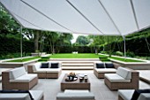 CONTEMPORARY TOWN/CITY/URBAN GARDEN DESIGNED BY CHARLOTTE SANDERSON: VIEW OF ENTERTAINING/RELAXING AREA WITH AWNING  TABLE  CHAIRS  SOFAS AND STEPS LEADING TO LAWN