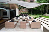 CONTEMPORARY TOWN/CITY/URBAN GARDEN DESIGNED BY CHARLOTTE SANDERSON: AWNING OVER ENTERTAINING/RELAXING AREA WITH TABLE  CHAIRS AND SOFAS AND STEPS LEADING TO LAWN