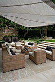 CONTEMPORARY TOWN/CITY/URBAN GARDEN DESIGNED BY CHARLOTTE SANDERSON: AWNING OVER ENTERTAINING/DINING AREA WITH TABLE/CHAIRS/SOFAS AND STEPS LEADIN TO LAWN