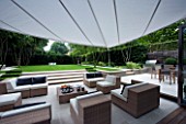 CONTEMPORARY TOWN/CITY/URBAN GARDEN DESIGNED BY CHARLOTTE SANDERSON: AWNING OVER OUTDOOR ENTERTAINING/RELAXING/DINING AREA WITH TABLE  CHAIRS AND SOFAS WITH STEPS LEADING TO LAWN