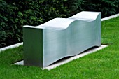 URBAN CONTEMPORARY MODERN MINIMALIST GARDEN DESIGNED BY CHARLOTTE SANDERSON: A PLACE TO SIT - METAL WAVE SEAT/ BENCH ON LAWN/ GRASS BESIDE YEW HEDGE