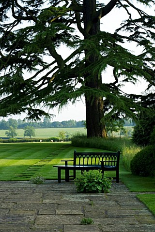 THE_OLD_RECTORY__HASELBECH__NORTHAMPTONSHIRE__PATIO_AREA_AND_LAWN_WITH_CEDAR_OF_LEBANON_AND_WOODEN_B