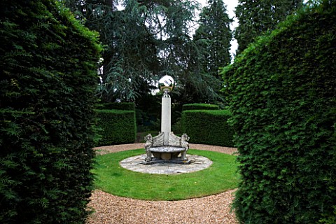 SUNDIAL_BY_DAVID_HARBER_SEEN_THROUGH_A_GAP_IN_YEW_HEDGING