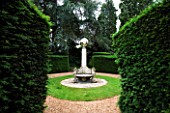 SUNDIAL BY DAVID HARBER SEEN THROUGH A GAP IN YEW HEDGING