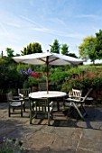 MARINERS GARDEN  BERKSHIRE  DESIGNER FENJA ANDERSON - TABLE  CHAIRS AND CANOPY ON THE PATIO BESIDE THE KITCHEN