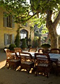 DESIGNER DOMINIQUE LAFOURCADE  PROVENCE  FRANCE - LARGE GRAVEL TERRACE WITH PROVENCAL FARMHOUSE  WICKER CHAIRS  TABLE