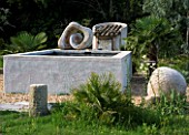 PROVENCE  FRANCE. GARDEN OF MARCO NUCERA. GRAVEL GARDEN WITH BEAUTIFUL WOODEN SCULPTURE AND WATER BASIN
