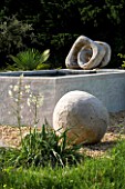 PROVENCE  FRANCE. GARDEN OF MARCO NUCERA. GRAVEL GARDEN WITH BEAUTIFUL WOODEN SCULPTURED BALL  YUCCA  WATER FEATURE AND TWISTED SCULPTURE