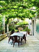 DESIGNER MICHEL SEMINI  PROVENCE  FRANCE. COURTYARD/ TERRACE WITH TABLE AND CHAIRS AND PERGOLA