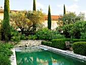 DESIGNER MICHEL SEMINI  PROVENCE  FRANCE. LIMESTONE POOL WITH WATER SPOUT IN THE EVENING