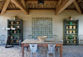 DESIGNER MICHEL SEMINI  PROVENCE  FRANCE. COVERED LOGIA DINING AREA WITHY TABLE  CHAIRS  MOROCCAN STYLE TILES  TELESCOPE