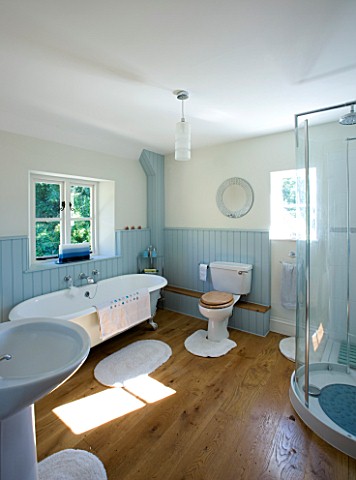 DESIGNER_CLARE_MATTHEWS_DEVON__BLUE_AND_WHITE_THEMED_BATHROOM_WITH_SHOWER_AND_ROLL_TOP_BATH