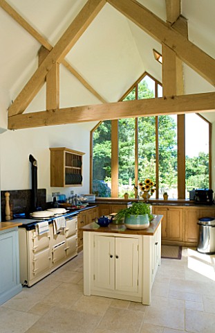 CLARE_MATTHEWS_HOUSE__DEVON_KITCHEN_EXTENSION_WITH_ISLAND__EXPOSED_ROOF_BEAMS__LIMESTONE_FLOOR_AND_A