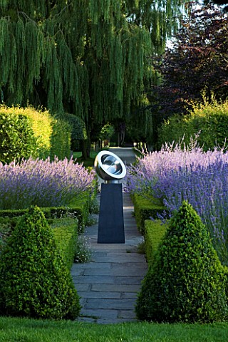 DAVID_HARBER_SUNDIALS_STAINLESS_STEEL_BEROSSOS_SUNDIAL_ON_PLINTH_IN_FORMAL_GARDEN_WITH_TOPIARY_PYRAM