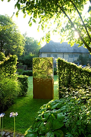 DAVID_HARBER_SUNDIALS_TITAN_SCULPTURE_ON_LAWN_MADE_FROM_RUSTIC_OXIDISED_STEEL_AND_MIRROR_POLISHED_ST