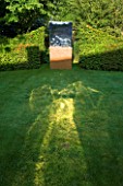 DAVID HARBER SUNDIALS: TITAN SCULPTURE MADE FROM RUSTIC OXIDISED STEEL AND MIRROR POLISHED STAINLESS STEEL. REFLECTION ON LAWN