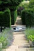 THROUGHAM COURT  GLOUCESTERSHIRE. DESIGNER: CHRISTINE FACER: VIEW FROM THE CHAOS GATE DOWN A PATH TO THE SLATE STARBURST BLACK REFLECTIVE POOL AND RILL