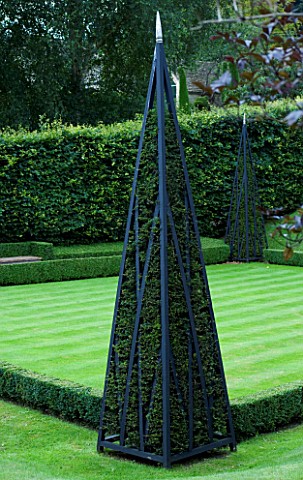 THROUGHAM_COURT__GLOUCESTERSHIRE_DESIGNER_CHRISTINE_FACER_WOODEN_TRIPOD_WITH_YEW_BESIDE_THE_CROQUET_